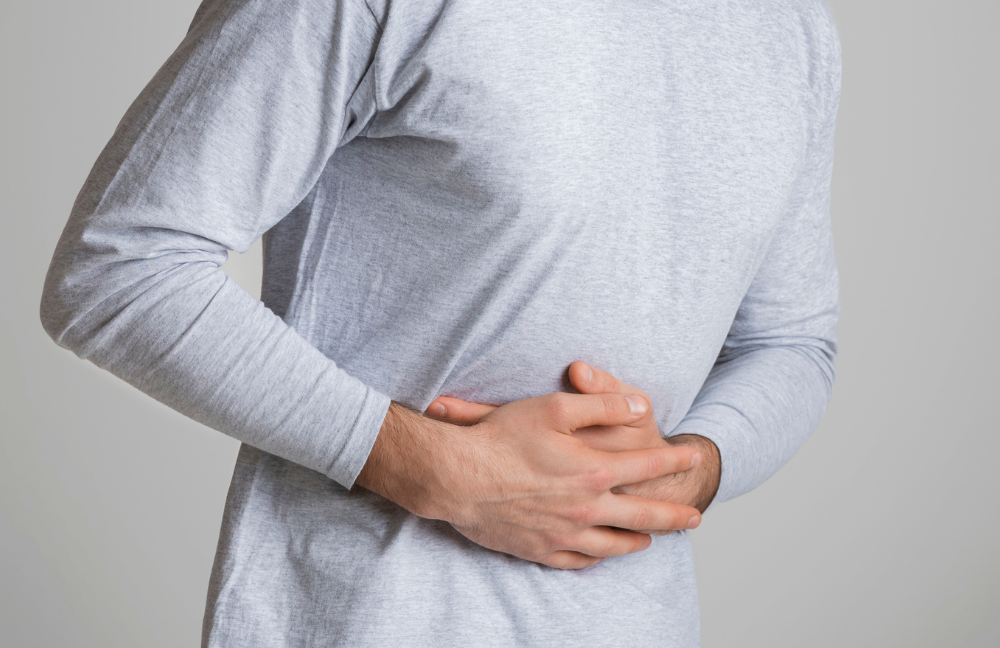 Man with IBS holding his stomach in pain