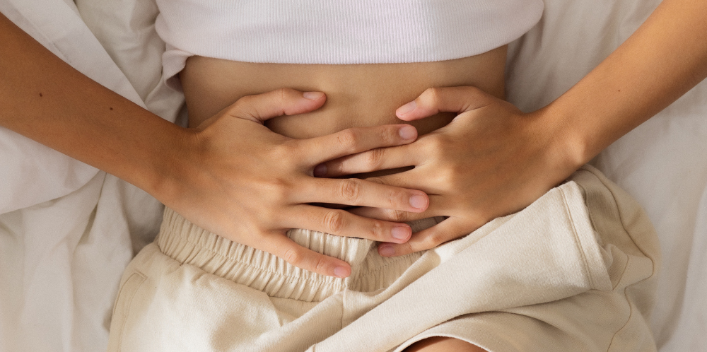 Person laying down and holding their lower abdomen