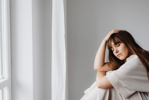 Person sitting down, holding their head in frustration