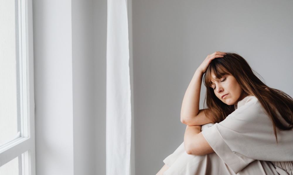 Person sitting down, holding their head in frustration